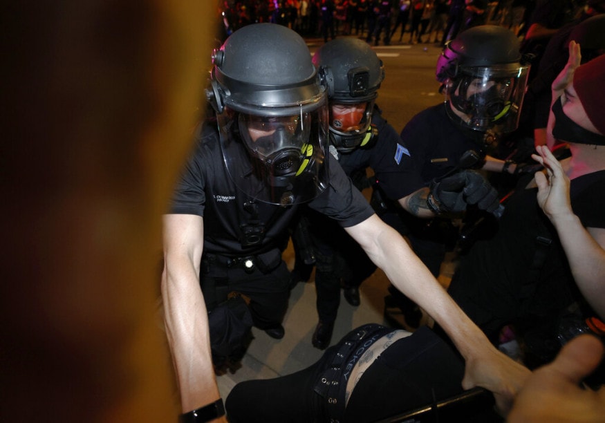  Denver police officers uses batons to push back protesters outside the State Capitol, in Denver, during a demonstration over the death of George Floyd in Minneapolis police custody. (Image: AP)