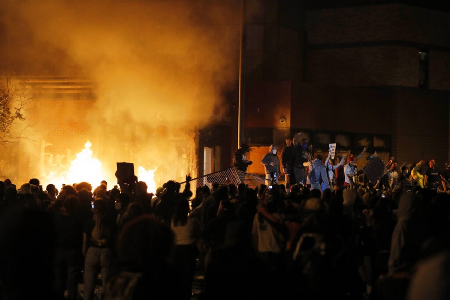  Protesters gather in front of the burning Minneapolis police 3rd Precinct building, in Minneapolis. (Image: AP)