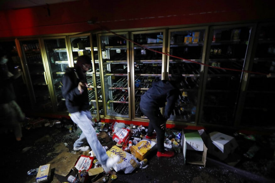  People take items from a liquor store, in Minneapolis. (Image: AP)