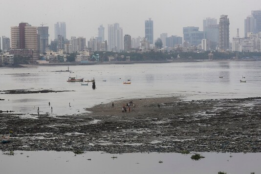 A group of boys play as boats are seen anchored on the Arabian Sea coast in Mumbai. (AP)