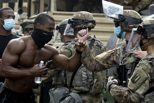 Demonstrators greet members of the National Guard as they march along Hollywood Boulevard, in the Hollywood section of Los Angeles, during a protest over the death of George Floyd, who died May 25 after he was restrained by Minneapolis police. (Image: AP)