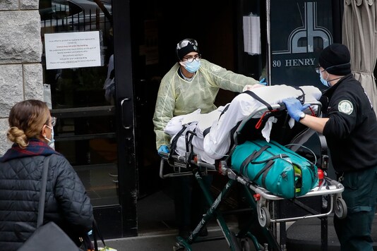 A patient is wheeled into Cobble Hill Health Center by emergency medical workers in the Brooklyn borough of New York. (AP Photo)