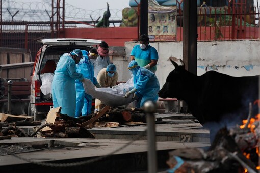 For representation: Relatives in personal protective suits of a person who died of COVID-19 place the body for cremation in New Delhi. (AP)