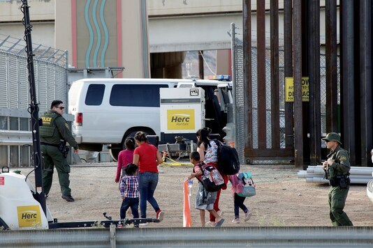 FILE PHOTO: U.S. Customs and Border Protection (CBP) agents look at migrants who crossed illegally into El Paso, Texas, U.S., to turn themselves in to ask for asylum, as seen from Ciudad Juarez, Mexico September 18, 2019. REUTERS/Jose Luis Gonzalez/File Photo