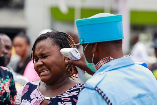 A security guard uses a thermal scanner to check a woman's temperature as she enters the Tejuoso shopping complex at the Yaba market, amid the coronavirus disease (COVID-19) outbreak, in Lagos, Nigeria March 23, 2020. (Photo: REUTERS/Temilade Adelaja)