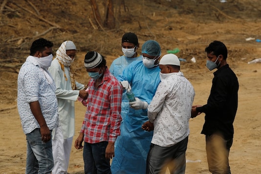 People use hand sanitizers to disinfect themselves after the burial of their relative who died of COVID-19, at a cemetery in New Delhi. (AP Photo/Manish Swarup) People use hand sanitizers to disinfect themselves after the burial of their relative who died of COVID-19, at a cemetery in New Delhi. (AP Photo/Manish Swarup)