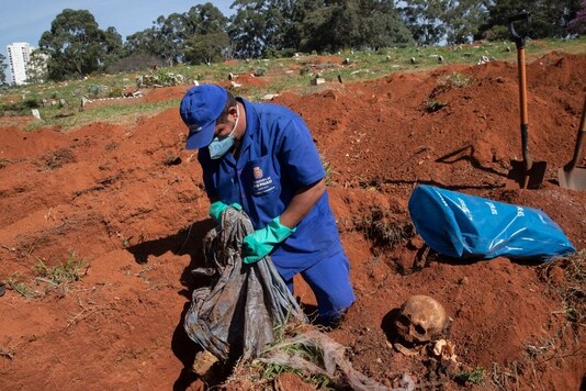 A cemetery worker exhumes the body of a person buried three years ago at the Vila Formosa cemetery, which does not charge families for the gravesites, in Sao Paulo, Brazil, Friday, June 12, 2020. Three years after burials, remains are routinely exhumated and stored in plastic bags to make room for more burials, which have increased amid the new coronavirus. (AP Photo/Andre Penner)


