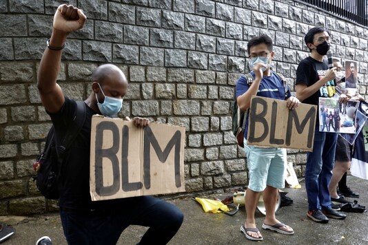Protesters hold Black Lives Matter signs during a demonstration against racism and police brutality in the aftermath of the death in Minneapolis police custody of George Floyd, outside the Consulate General of U.S. in Hong Kong, China June 7, 2020. REUTERS/Joyce Zhou