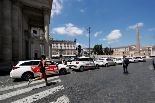 A man runs past taxis on the Piazza del Popolo, after Italy opened its borders to European countries allowing free movement after the coronavirus disease (COVID-19) lockdown, in Rome, Italy, June 12, 2020. REUTERS/Yara Nardi