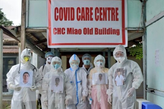 Doctors posing outside the hospital wearing PPE suits.