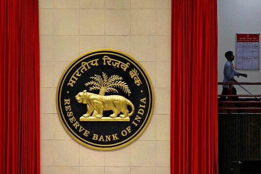 FILE PHOTO: A worker walks past the logo of Reserve Bank of India (RBI) inside its office in New Delhi, India July 8, 2019. REUTERS/Anushree Fadnavis/File Photo