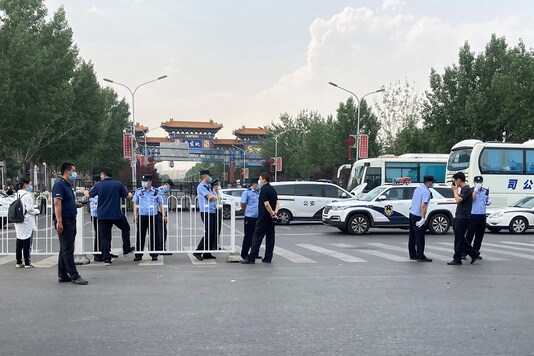 Police officers wearing face masks are seen outside an entrance of the Xinfadi wholesale market, which has been closed for business after new coronavirus infections were detected, in Beijing. (Reuters)