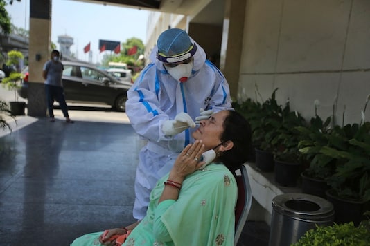 In this representative image, a woman gets nasal swab taken to test for the coronavirus. (AP Photo/ Channi Anand)