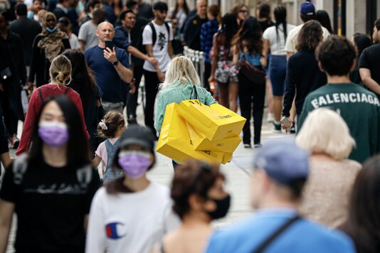 People walk with bags after shopping at the Selfridges department store in London, Monday, June 15, 2020. After three months of being closed under coronavirus restrictions, shops selling fashion, toys and other non-essential goods are being allowed to reopen across England for the first time since the country went into lockdown in March.(AP Photo/Matt Dunham)
