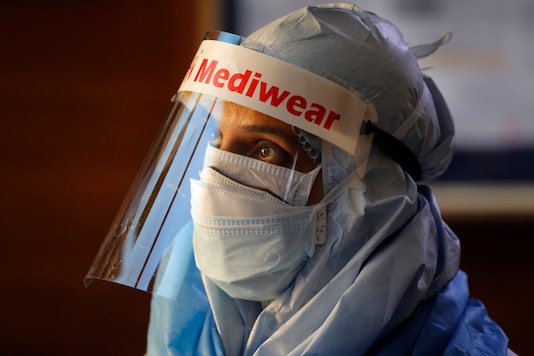 A health worker in protective suit listens to people standing in a queue for COVID 19 test at Sir Ganga Ram hospital in New Delhi, India, Tuesday, June 16, 2020. India is the fourth hardest-hit country by the COVID-19 pandemic in the world after the U.S., Russia and Brazil. (AP Photo/Manish Swarup)