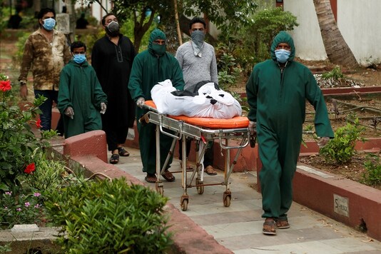 Volunteers carry the body of a victim, who died from the coronavirus disease,at a graveyard in Mumbai. (REUTERS)