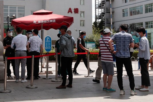 People gather outside a hospital to seek information about the appointment for a nucleic acid test in Beijing. (AP Photo/Andy Wong)