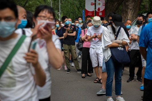 People wait in line at a Covid-19 testing site after they were ordered by the government to be tested after potentially being exposed to the coronavirus outbreak at a wholesale food market in Beijing, on June 17, 2020. (AP Photo/Mark Schiefelbein)