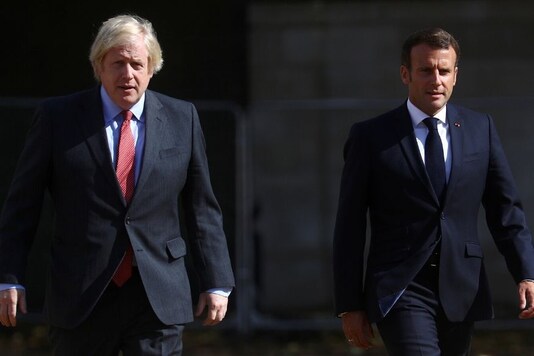 British Prime Minister Boris Johnson and French President Emmanuel Macron walk after watching The Red Arrows and La Patrouille de France perform a flypast, at Horse Guards Parade in London, Britain, June 18, 2020. REUTERS/Hannah McKay/Pool