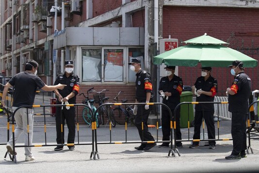 Security guards prepare for duty near a neighborhood under lockdown in Beijing. (Image:AP)