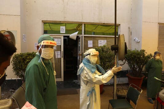 Health workers in protective suits talk to people standing in a queue for Covid-19 test at Sir Ganga Ram hospital in New Delhi, on June 16, 2020. (AP Photo/Manish Swarup)