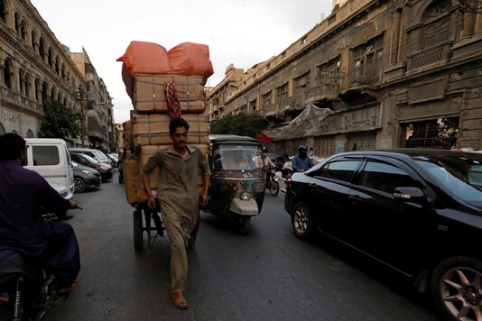 A laborer pulls a hand cart as he delivers supplies to a nearby market, amid the outbreak of the coronavirus disease (COVID-19), in Karachi, Pakistan, June 12, 2020. REUTERS/Akhtar Soomro