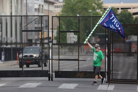 A man waves a Donald Trump campaign flag near a barricade in downtown Tulsa, Oklahama ahead of the president's rally on Saturday. (Reuters)