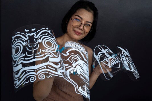 Maysa Talerd, 31, an entrepreneur, holds up her own designs for face shields, as she poses during an interview with Reuters amid the spread of the coronavirus (COVID-19) disease in Bangkok, Thailand