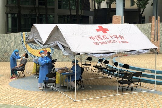 A woman receives a nucleic acid test at a makeshift testing site in a residential compound in Beijing. REUTERS/Carlos Garcia Rawlins