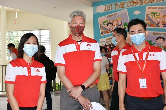 Lee Hsien Yang, center, brother of Singapore Prime Minister Lee Hsien Loong, poses for a photo in Singapore Wednesday. (AP)
