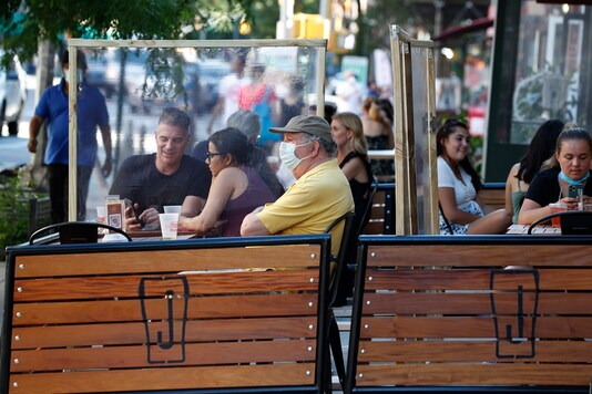 Plastic partitions separate patrons at Jake's Dilemma the first day of the phase two reopening of the city during the current coronavirus outbreak, Monday, June 22, 2020, in New York. In phase two, restaurants are allowed have customers seated for outdoor dining but with some restrictions. (AP Photo/Kathy Willens)