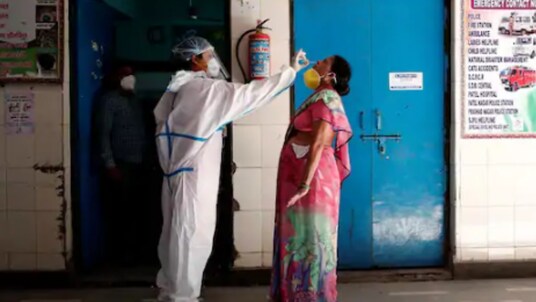 A medical worker collects a sample from a woman at a school turned into a centre to conduct tests for the coronavirus disease (COVID-19), amidst its spread in New Delhi on Monday. (Reuters)