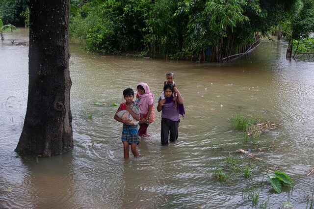 Villagers wade through flood water in Morigaon district of Assam.  (AP Photo/Anupam Nath)