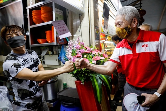 Lee Hsien Yang of the Progress Singapore Party (PSP) greets a hawker during a walkabout ahead of the general election in Singapore June 28, 2020. REUTERS/Edgar Su