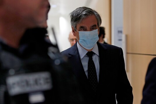 Former French prime minister Francois Fillon, wearing a protective face mask, arrives for the verdict in his trial over a fake jobs scandal at the courthouse in Paris, France, June 29, 2020. REUTERS/Gonzalo Fuentes