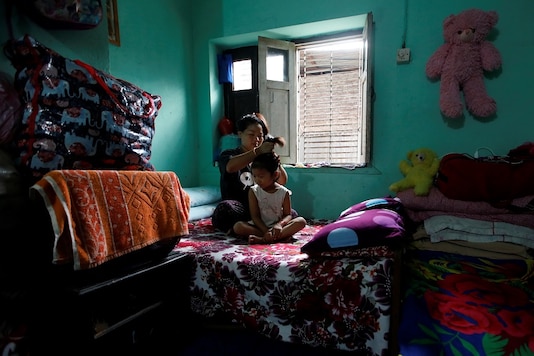 Nepali housewife Shiba Kala Limbu ties up her five-year-old daughter Masim Limbu's hair in Kathmandu, Nepal June 25, 2020. More than 56 percent of Nepal's estimated 5.4 million households receive remittances that are a vital lifeline for thousands of families, who are without any other source of income, according to official figures. Picture taken June 25, 2020. (REUTERS)