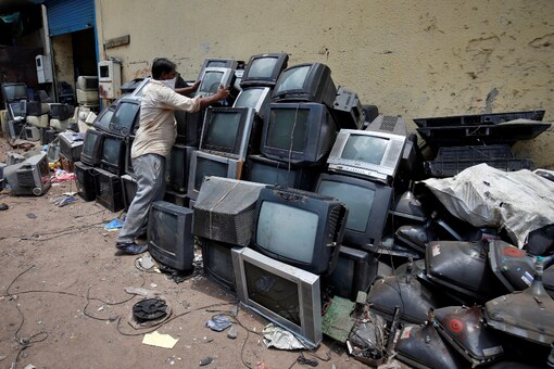 A scrap dealer piles up discarded TV sets before dismantling them at a scrap yard in Ahmedabad, India, July 2, 2020. REUTERS/Amit Dave
