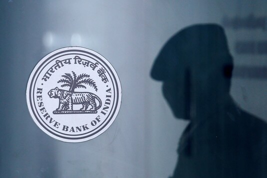 A security guard's reflection is seen next to the logo of the Reserve Bank Of India (RBI) at the RBI headquarters in Mumbai, India, June 6, 2019. (Image: REUTERS)