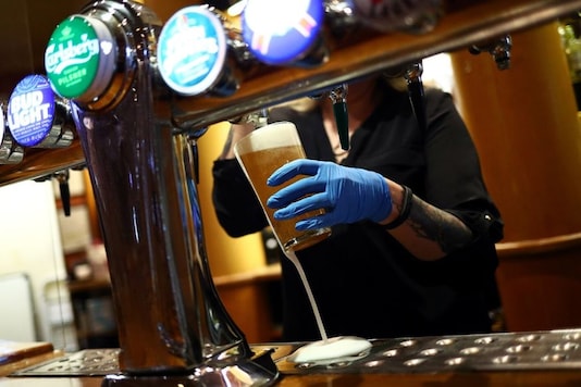 A worker serves a beer at The Holland Tringham Wetherspoons pub after it reopened following the outbreak of the coronavirus disease (COVID-19), in London, Britain July 4, 2020. REUTERS/Hannah McKay A worker serves a beer at The Holland Tringham Wetherspoons pub after it reopened following the outbreak of the coronavirus disease (COVID-19), in London, Britain July 4, 2020. REUTERS/Hannah McKay