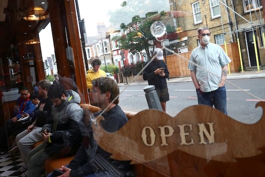 People wait inside and others queue outside Savvas Barbers as it reopened following the outbreak of the coronavirus disease (COVID-19), in London, Britain July 4, 2020. REUTERS/Hannah McKay People wait inside and others queue outside Savvas Barbers as it reopened following the outbreak of the coronavirus disease (COVID-19), in London, Britain July 4, 2020. REUTERS/Hannah McKay