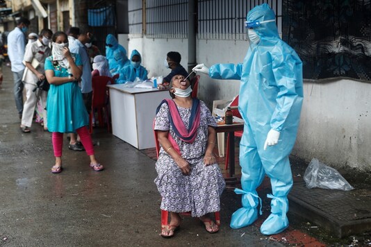 A healthcare worker collects a swab sample from a woman during a medical campaign for the coronavirus disease. (Reuters)