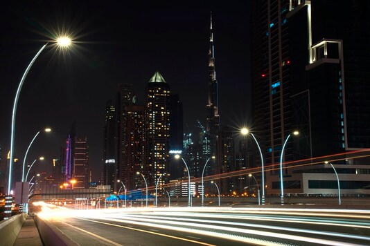 In this photo taken with a slow shutter speed, traffic speeds down the Sheikh Zayed Road in Dubai, United Arab Emirates, Monday, July 6, 2020. (AP Photo/Jon Gambrell)