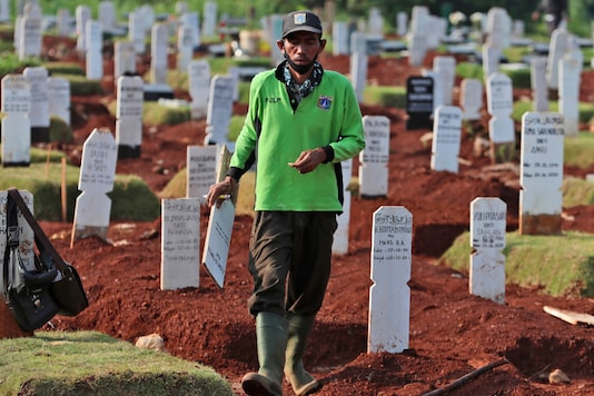 A worker walks among graves at a special cemetery for people who presumably died of COVID-19 at a cemetery in Jakarta, Indonesia Friday, June 12, 2020. As Indonesia’s virus death toll rises, the world’s most populous Muslim country finds itself at odds with protocols put in place by the government to handle the bodies of victims of the pandemic. This has led to increasing incidents of bodies being taken from hospitals, rejection of COVID-19 health and safety procedures, and what some experts say is a lack of communication from the government. (AP Photo/Achmad Ibrahim)
A worker walks among graves at a special cemetery for people who presumably died of COVID-19 at a cemetery in Jakarta, Indonesia Friday, June 12, 2020. As Indonesia’s virus death toll rises, the world’s most populous Muslim country finds itself at odds with protocols put in place by the government to handle the bodies of victims of the pandemic. This has led to increasing incidents of bodies being taken from hospitals, rejection of COVID-19 health and safety procedures, and what some experts say is a lack of communication from the government. (AP Photo/Achmad Ibrahim)