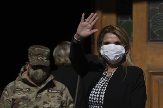 Bolivia's interim President Jeanine Anez, wearing a face mask to help curb the spread of the new coronavirus, waves during a procession Corpus Christi, in La Paz, Bolivia, Thursday, June 11, 2020. AP Photo/Juan Karita