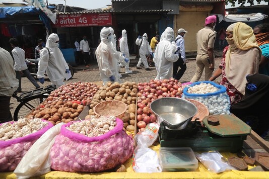 Health workers arrive to screen people at a slum in Mumbai on Friday. (AP)