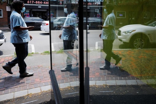 A pedestrian is reflected in the window of an empty storefront, in a city hard hit by the coronavirus disease (COVID-19) outbreak, in Chelsea, Massachusetts, U.S., July 9, 2020. REUTERS/Brian Snyder
