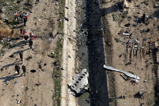 File photo of rescue workers searching the scene where a Ukrainian plane crashed in Shahedshahr, southwest of Tehran, Iran. (AP)