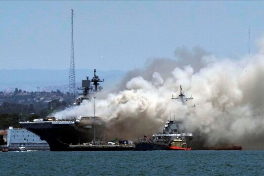 Smoke rises from a fire on board the US Navy amphibious assault ship USS Bonhomme Richard at Naval Base San Diego, as seen from Coronado, California, U.S. July 12, 2020. (REUTERS/Bing Guan)