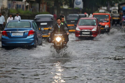 People commute through a water-logged road street after rains in Mumbai (Representational Image: Reuters)