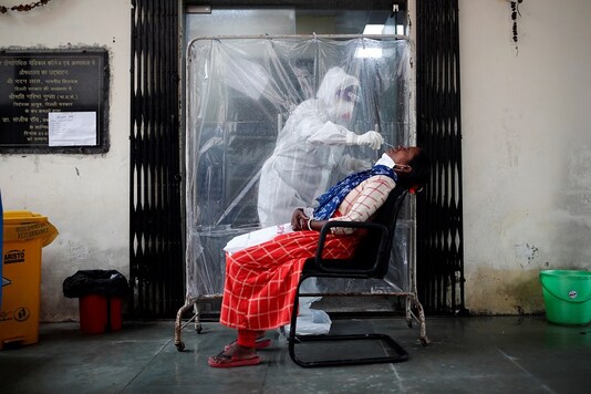 A health worker in personal protective equipment collects a sample using a swab from a woman at a local health centre to conduct tests for the coronavirus disease. (Reuters)